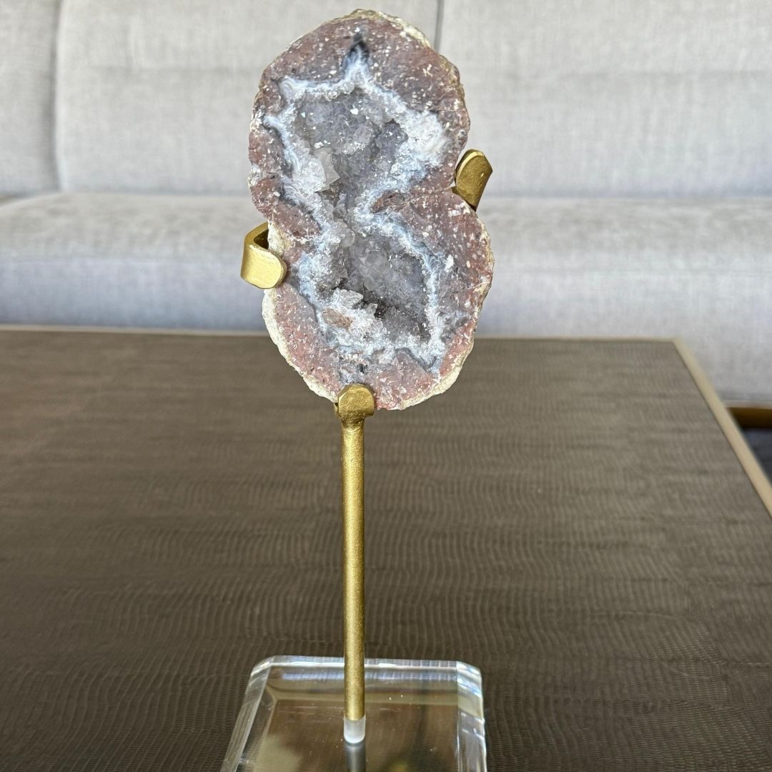 GEODA DE CUARZO CON PEDESTAL en tonos grises y rojizos montada con un base acrílica, producto exclusivo de SSIENTO en Saltillo, ideal como pieza decorativa y simbólica para transmitir energía espiritual y elegancia en el hogar